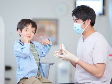 歯ブラシを持っている男の子と歯科医師
